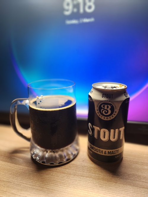 Stout beer by boat rocker on a desk in front a monitor